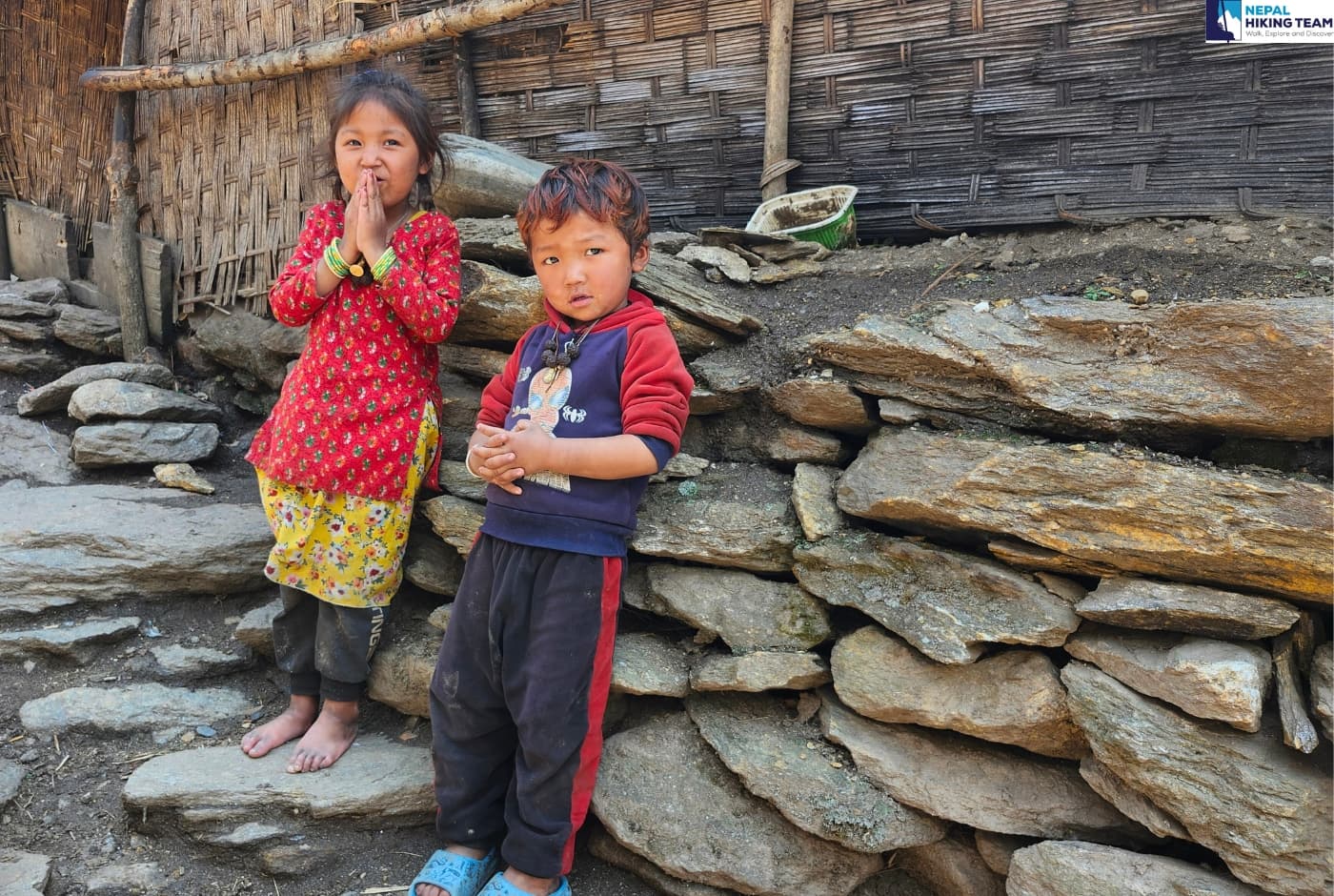 Two kids welcoming guest in Manslu with a Namaste