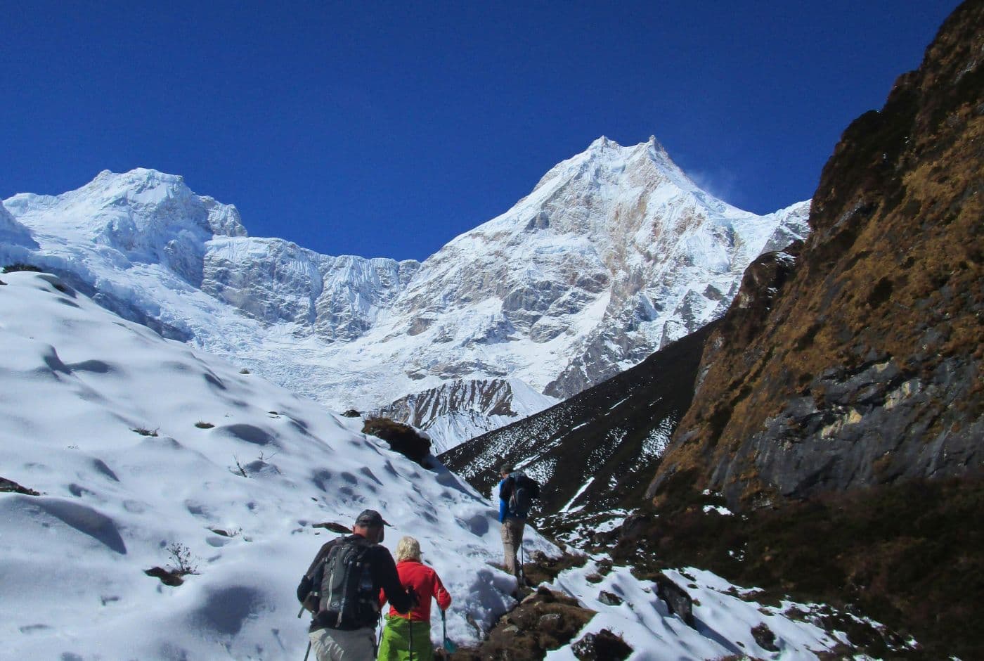 Hikers alsong the snowy and rocky path of Tsum valley