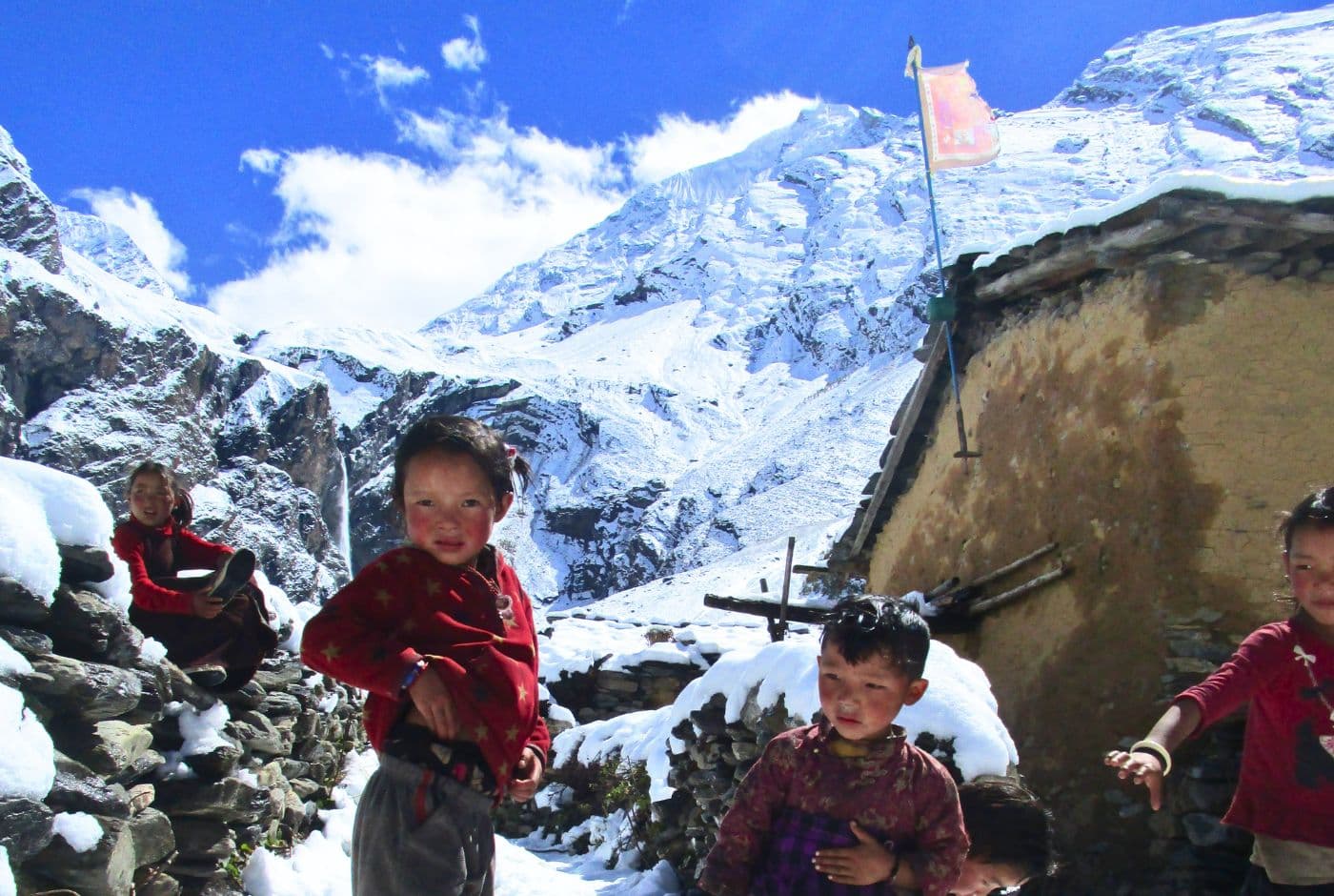 Local children playing in snowy mountains of Tsum Valley