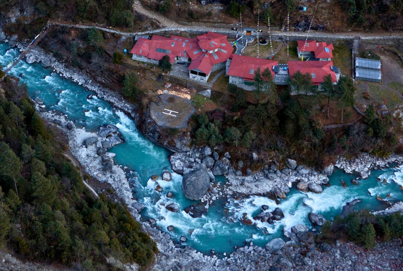 Riverside lodge, aerial view, mountain resort, prayer flags   Phakding