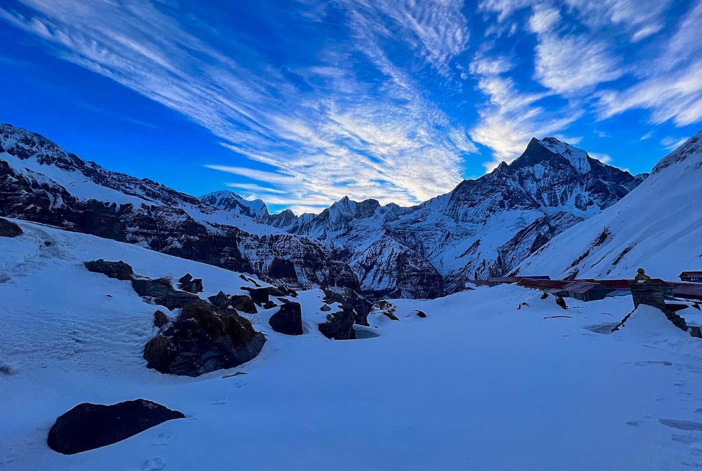 Snow-covered Annapurna Sanctuary with Machhapuchhre peak rising under vivid blue skies, ABC Trek