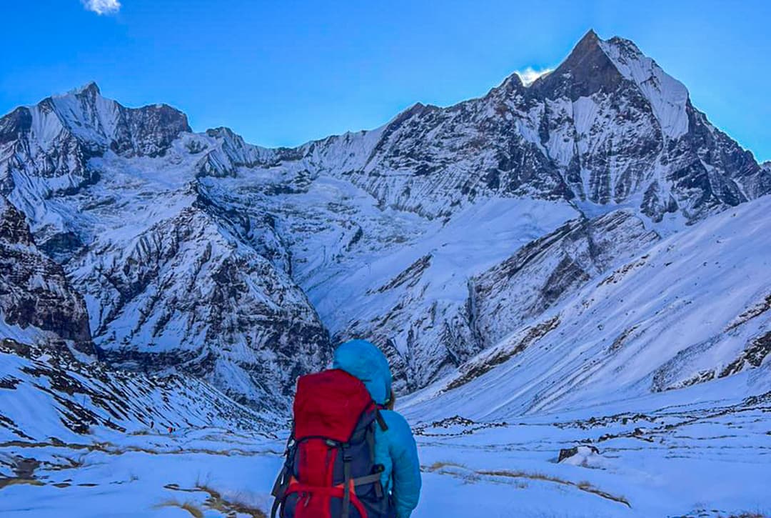 Trekker Descending Snowy Trail From Annapurna Base Camp With Machhapuchhre (Fishtail) Peak In Background
