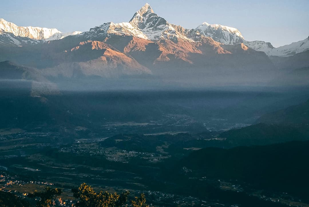 Pokhara valley sunrise panorama showing Machhapuchhre and Annapurna Himalayas with fog layer over city