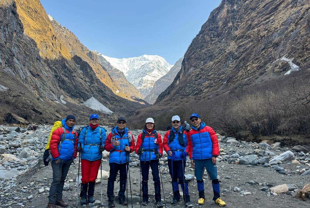 Trekkers Posing For A Photo with Trekking poles at Deurali with mountain backdrop